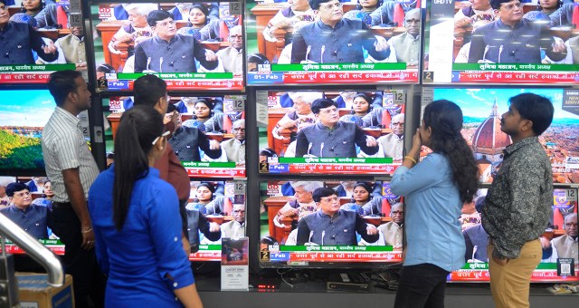 People at an electronics shop in Kolkata, India, watch as Finance Minister Piyush Goyal presents the country's interim budget on Feb. 1. (Samir Jana/Hindustan Times via Getty Images)