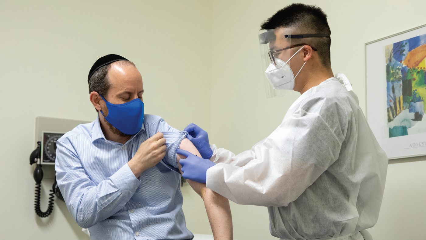 Rabbi Shmuel Herzfeld has his arm disinfected by Dr. Chao Wang during a clinical trial for a Coronavirus vaccine.(Amanda Andrade-Rhoades/Getty Images)