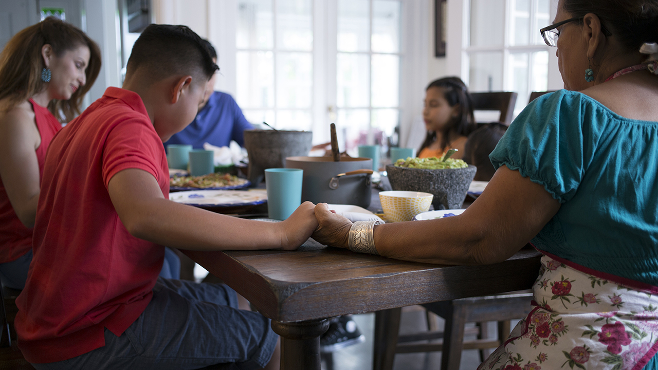 A family is at the dinner table. The son asks the father, “Dad