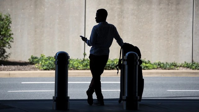 A traveler waits to be picked up by a ride-hailing service at Ronald Reagan Washington National Airport. (Tom Williams/CQ Roll Call)