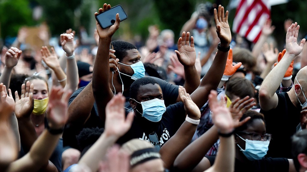 Protesters kneel and hold up their hands in Lafayette Square, near the White House, on June 4 to protest the death of George Floyd. (Olivier Douliery/AFP via Getty Images)