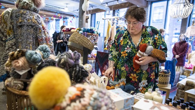 A small business owner organizes display tables at a yarn store in Boston.  (Erin Clark/Boston Globe via Getty Images)