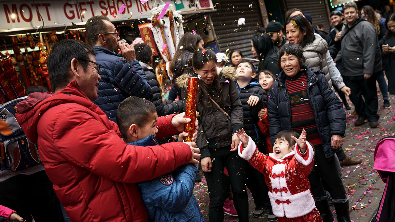 A family pops confetti to celebrate the start of Chinese New Year at a February 2018 festival in New York City's Chinatown. (Drew Angerer/Getty Images)