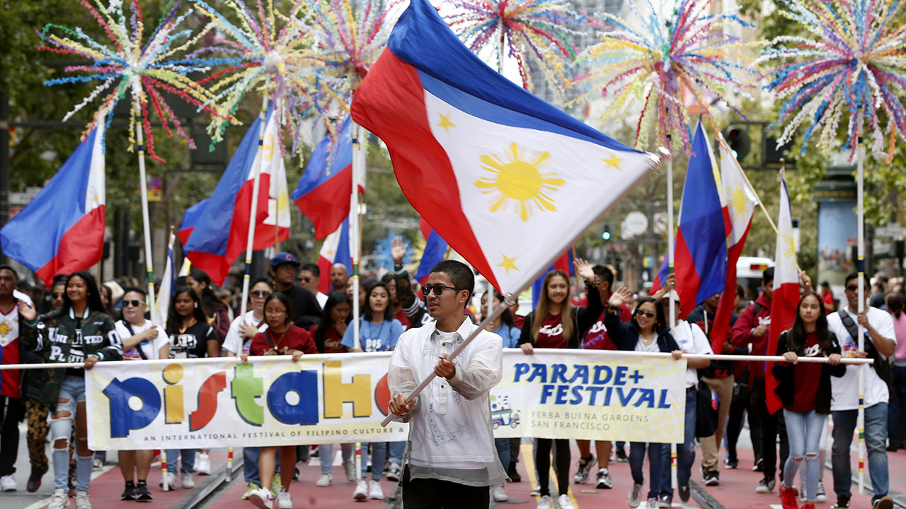 Pinangunahan ng mga nagmamartsa na iwinawagayway ang pambansang watawat ng Pilipinas ang Pistahan Parade sa Market Street sa San Francisco sa isang pagdiriwang na ipinabubunyi ang kulturang Pilipino noong Agosto 2019. (Paul Chinn/The San Francisco Chronicle via Getty Images)