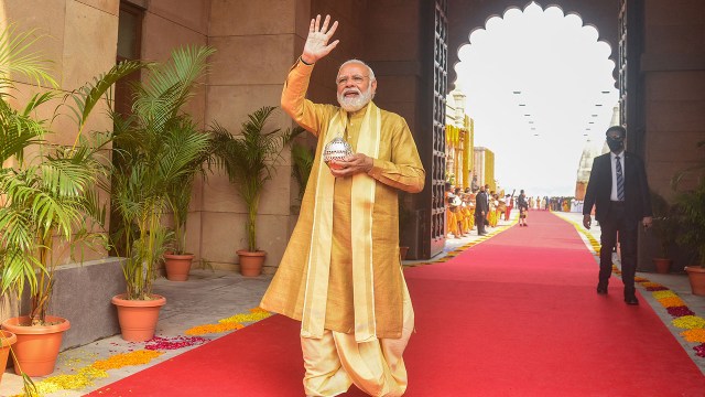 Indian Prime Minister Narendra Modi carries holy water from the Ganges River to offer prayers as he arrives to inaugurate the Kashi Vishwanath Dham Corridor in Varanasi on Dec. 13, 2021. (Sanjay Kanojia/AFP via Getty Images)